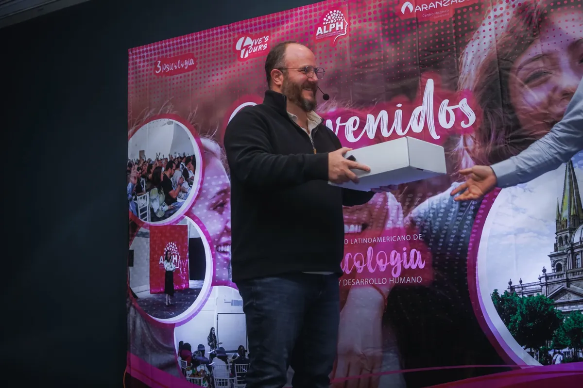 Ponente recibiendo un reconocimiento en el escenario del congreso