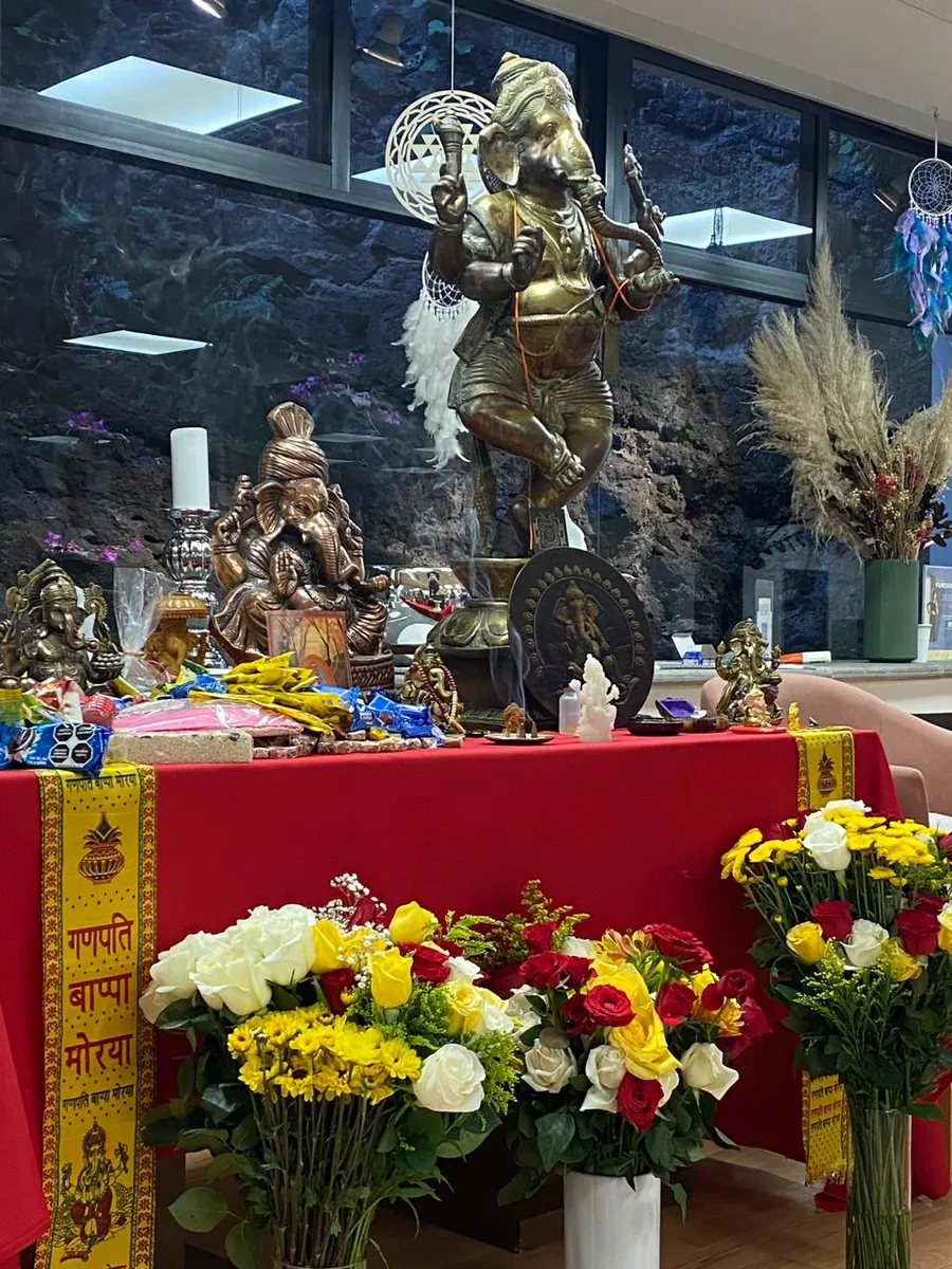 Altar con la figura de Ganesha, flores y ofrendas